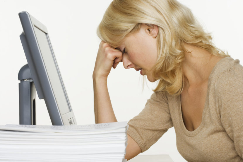 The Writer’s Funk Frustrated Woman at Computer With Stack of Paper